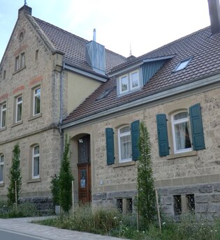 Außenansicht der alten Schule mit Natursteinen