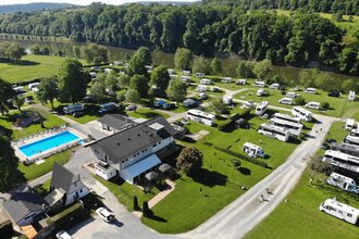 Blick auf einen Campingplatz mit einem Freibad und vielen Wohnmobilen. Im Hintergrund fließt ein Fluß (Neckar). Neckarzimmern im Odenwald