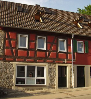 Das Fachwerkhaus von außen ist mit roter Farbe angestrichen