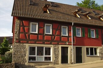 Das Fachwerkhaus von außen ist mit roter Farbe angestrichen