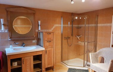 Im Bad gibt es eine bodengleiche Dusche und ein großes Waschbecken