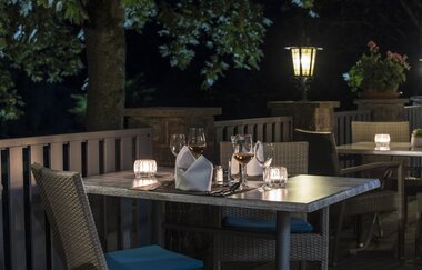 Außenterrasse am Abend mit Kerzen auf den Tischen