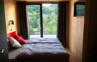 Im Schlafzimmer steht ein Doppelbett und ein TV-Gerät hängt gegenüber