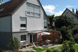 Die Außenansicht des Hauses mit überdachtem Sitzplatz