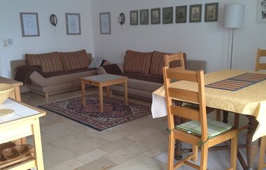 Im Wohnraum gibt es eine Schlafcouch und einen Tisch mit vier Stühlen.