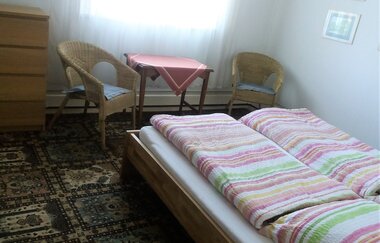 Im Schlafzimmer steht ein Doppelbett und ein Tisch mit zwei Stühlen