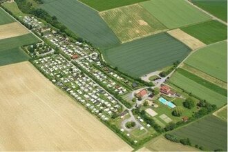 Luftaufnahme eines Campingplatzes inmitten von Wiesen und Feldern