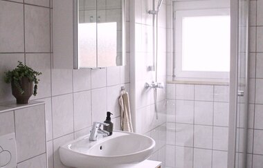 Modernes Badezimmer in weiß mit Dusche und Waschbecken