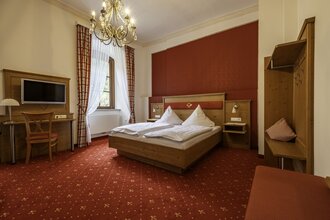 Gemütliches Doppelbett mit Fernseher und Kofferablage