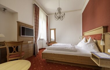 Komfortables Doppelbett mit Schreibtisch und Fernseher