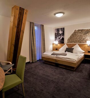 Ein Hotelzimmer mit Doppelbett und Sitzgelegenheit