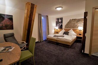 Ein Hotelzimmer mit Doppelbett und Sitzgelegenheit