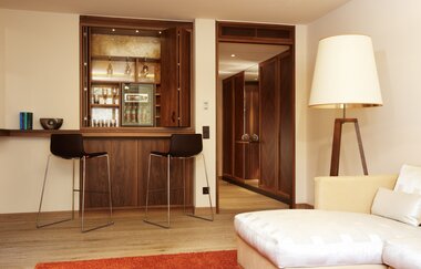 In diesem immer steht eine weiße Couch und es gibt eine kleine Bar