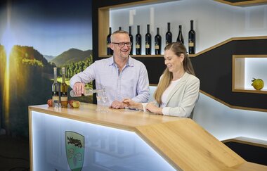 In der modernen Vinothek steht ein Paar und probiert Weine