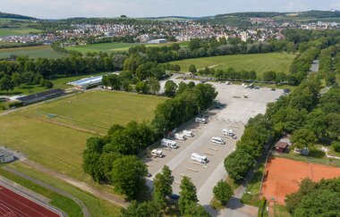 Eine Luftaufnahme vom Wohnmobilstellplatz von weiter oben. Im Hintergrund sieht man Bad Mergentheim.