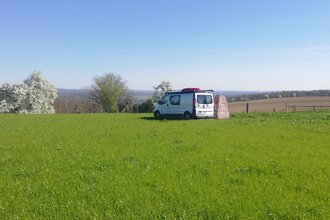 Eine große grüne Wiese mit einem kleineren Wohnmobil. Haßmersheim im Odenwald.