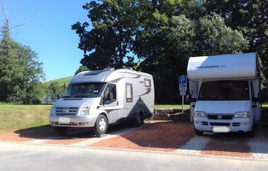Blick auf den Wohnmobilstellplatz in Markelsheim. Hier ist Platz für zwei Fahrzeuge. Im Hintergrund sind große Bäume zu sehen.