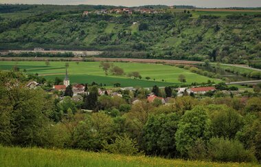 Man sieht eine kleine Gemeinde eingebettet in grüne Wieen und Wälder. Obrigheim im Odenwald.