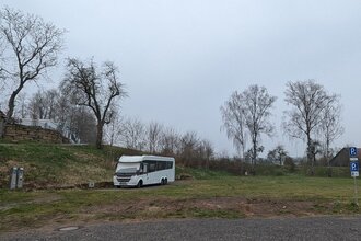 Es ist ein weißes Wohnmobil zu sehen. Dieses steht auf einem Platz im grünen. Im Hintergrund sind Bäume zu sehen. Der Platz ist in der Stadt Ravenstein im Odenwald