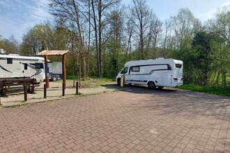 Ein gepflasterter Platz mit zwei weißen Wohnmobilen. Im Hintergrund ist eine Informationstafel. Mosbach im Odenwald.