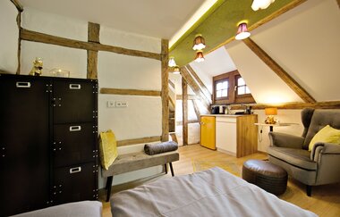 Appartment mit Betten, Sessel und Schränken