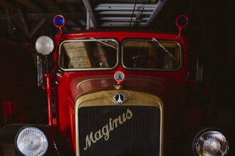 Ein rotes, historisches Feuerwehrfahrzeug der Marke Magirus im Feuerwehrmuseum Schwäbisch Hall.