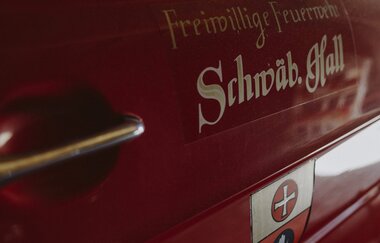 Nahaufnahme eines roten Feuerwehrfahrzeugs mit der Aufschrift 'Freiwillige Feuerwehr Schwäbisch Hall'.