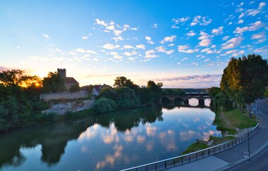 Blick über den Fluss zum Rathausburg in Lauffen am Neckar bei Sonnenuntergang.
