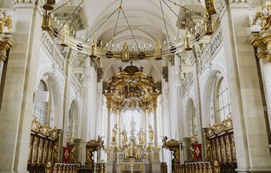 Innenansicht der Kirche Großcomburg in Schwäbisch Hall mit reich verziertem Altar und goldenen Dekorationen.