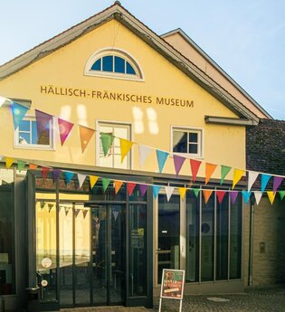 Eingang des Hällisch-Fränkischen Museums mit bunten Wimpeln dekoriert.