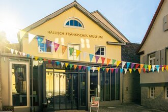 Eingang des Hällisch-Fränkischen Museums mit bunten Wimpeln dekoriert.