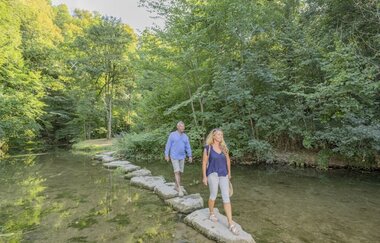 Hammerschmiede umgeben mit grünen Bäumen und zu sehen sind 2 Menschen