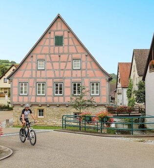 Ein Radfahrer fährt vor dem historischen Fachwerk-Rathaus