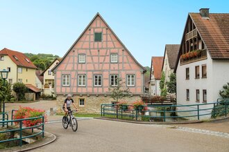 Ein Radfahrer fährt vor dem historischen Fachwerk-Rathaus