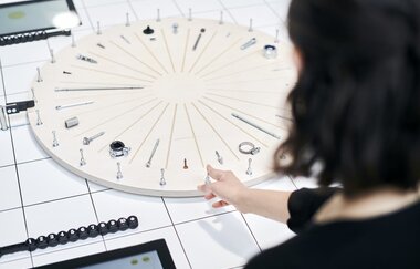 Eine Person steht vor einem Rad mit verschiedenen Schrauben und Muttern