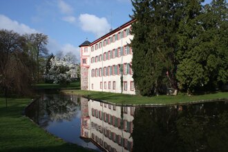 Seitenansicht Wasserschloss Eichtersheim mit See und Bäumen