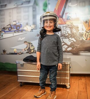 Kind mit Feuerwehrhelm in der BLAULICHT Ausstellung