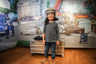 Kind mit Feuerwehrhelm in der BLAULICHT Ausstellung