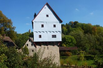 Blick auf das Topplerschlösschen in Rothenburg o.d.T. Ein kleines Häuschen steht auf einem alten Turm als Sockel.