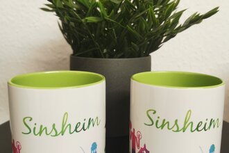 Zwei Tassen mit Sinsheim-Skyline und grünem Schriftzug
