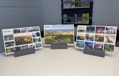 Drei verschiedene bunte Postkarten mit Sinsheimer Fotos in Halterung