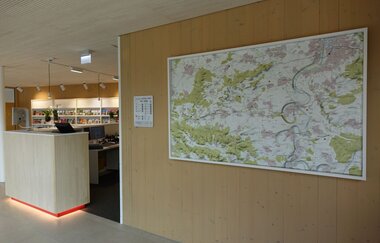 Blick auf die Reliefkarte im Innenbereich der Tourist-Information. Am linken Bildrand ist die Theke sowie die Prospektauslage zu sehen.