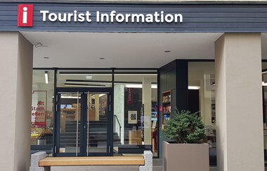 Eingang zur Tourist Information in Schwäbisch Hall mit Glasfront und Informationsmaterialien.