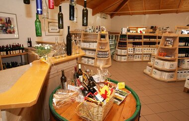 Blick in die Vinothek, verschiedene Regale mit Weinflaschen sowie Weinpräsente.
