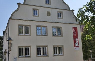 Das Haus ist historisch mit vielen Fenstern und einem Giebel
