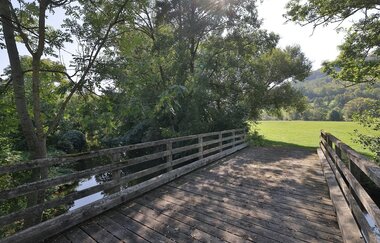 Eine Holzbrücke führt bei Ailringen über die Jagst