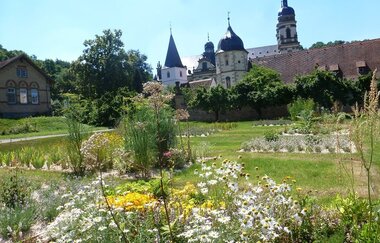 Im Garten blühen Arzneipflanzen und man kann auf das Kloster schauen
