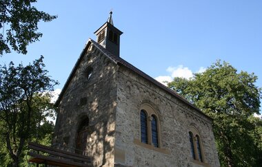 Die Kirche hat historische Rundfenster und einen spitzen Turm.