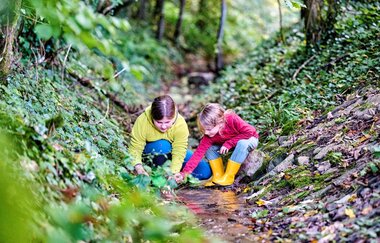 Kinder spielen im Bach